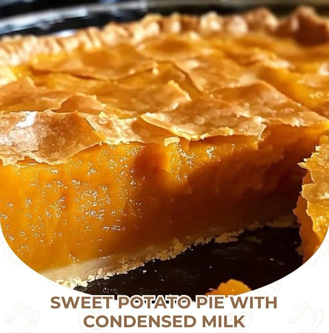 A golden-brown sweet potato pie with a flaky crust, topped with whipped cream, served on a rustic wooden table.