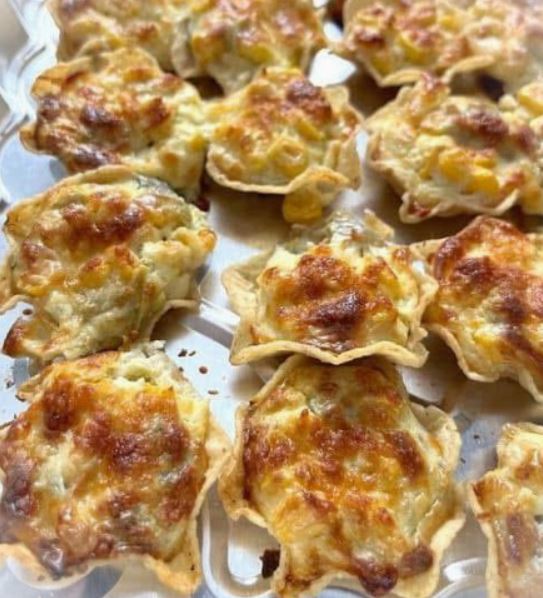 A tray of crispy tortilla scoops filled with melted cheese, corn, and chilies, fresh out of the oven