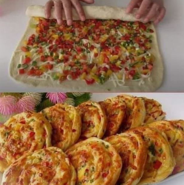 A loaf of golden veggie-filled bread, sliced open to reveal colorful peppers and onions